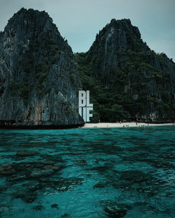 Tropical island with rocky cliffs and clear blue water, featuring the word 'BLUE'.